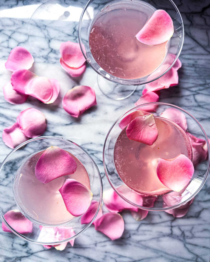 Pink Martini, Gine, Lychee and Rose Martini on marble board with pink roes petals